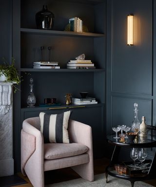 corner of blue living room with armchair and wall light