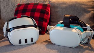 A Meta Quest 2 and Meta Quest 3 headset on a couch with a plaid pillow in the background