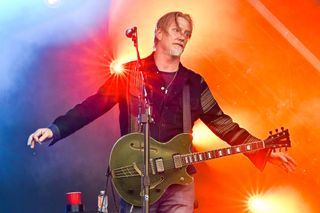 A picture of Josh Homme performing with Queens of the Stone Age in 2023