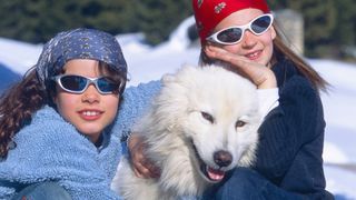 Two girls with Samoyed pet dog