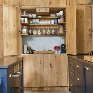 kitchen pantry with glass jars in wooden cupboard