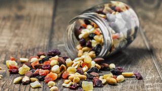 Jar of trail mix spilled on wooden table