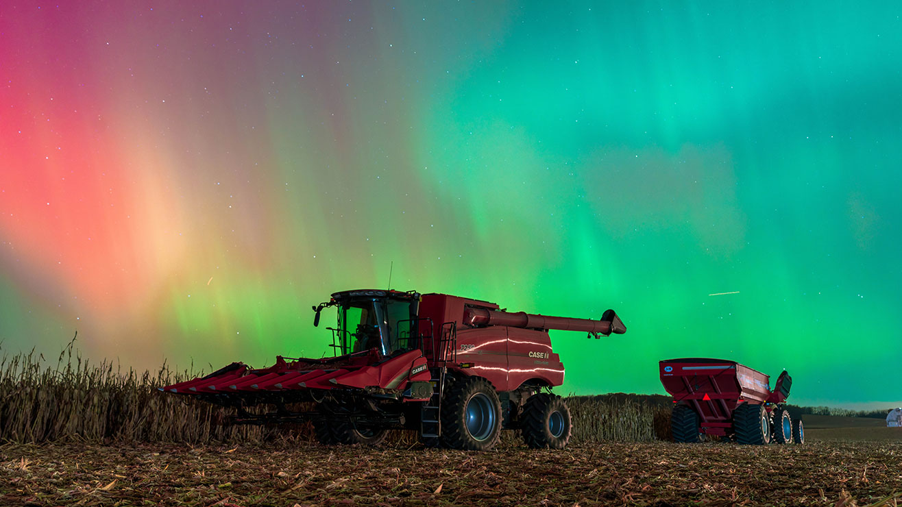Solar Storm Lights Up Wisconsin Farmland with a combine harvester In Rare Aurora Spectacle