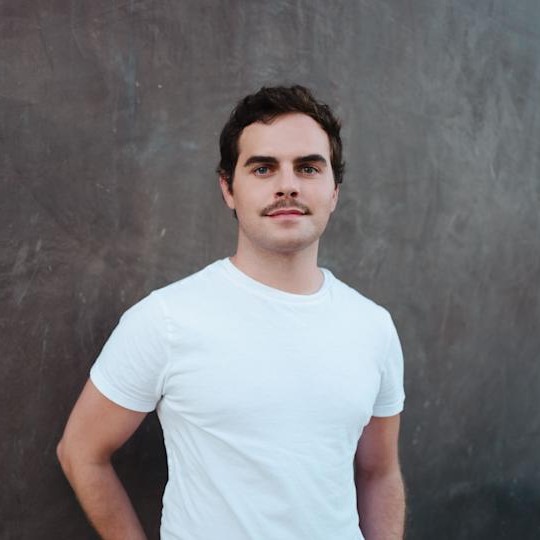 Celebrity colorist Jacob Schwartz poses in a white t-shirt.