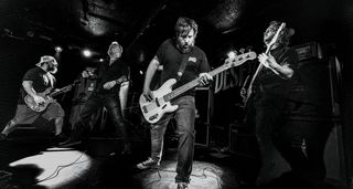 A black-and-white action shot of Sergeant Thunderhoof perform live: [from left] Mark Sayer, Dan Flitcroft, Jim Camp and Josh Gallop