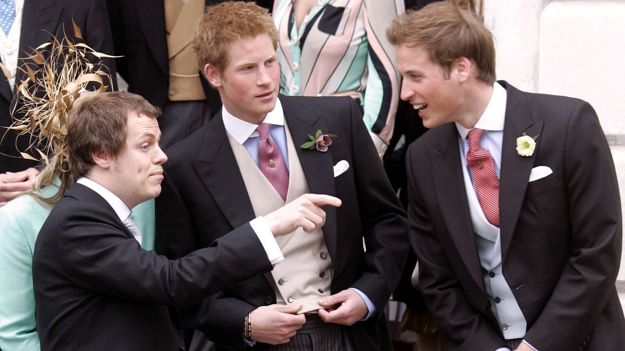 Tom Parker Bowles pointing while talking to Prince William and Harry, all of them wearing morning suits