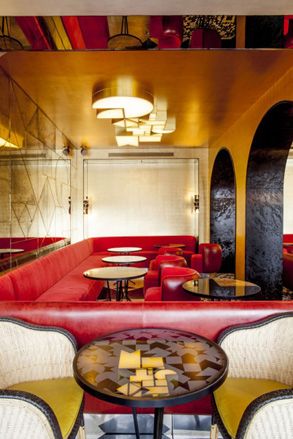 Rounded archways enter to large red couch seating areas