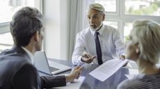 A financial adviser explains a strategy to a client couple.