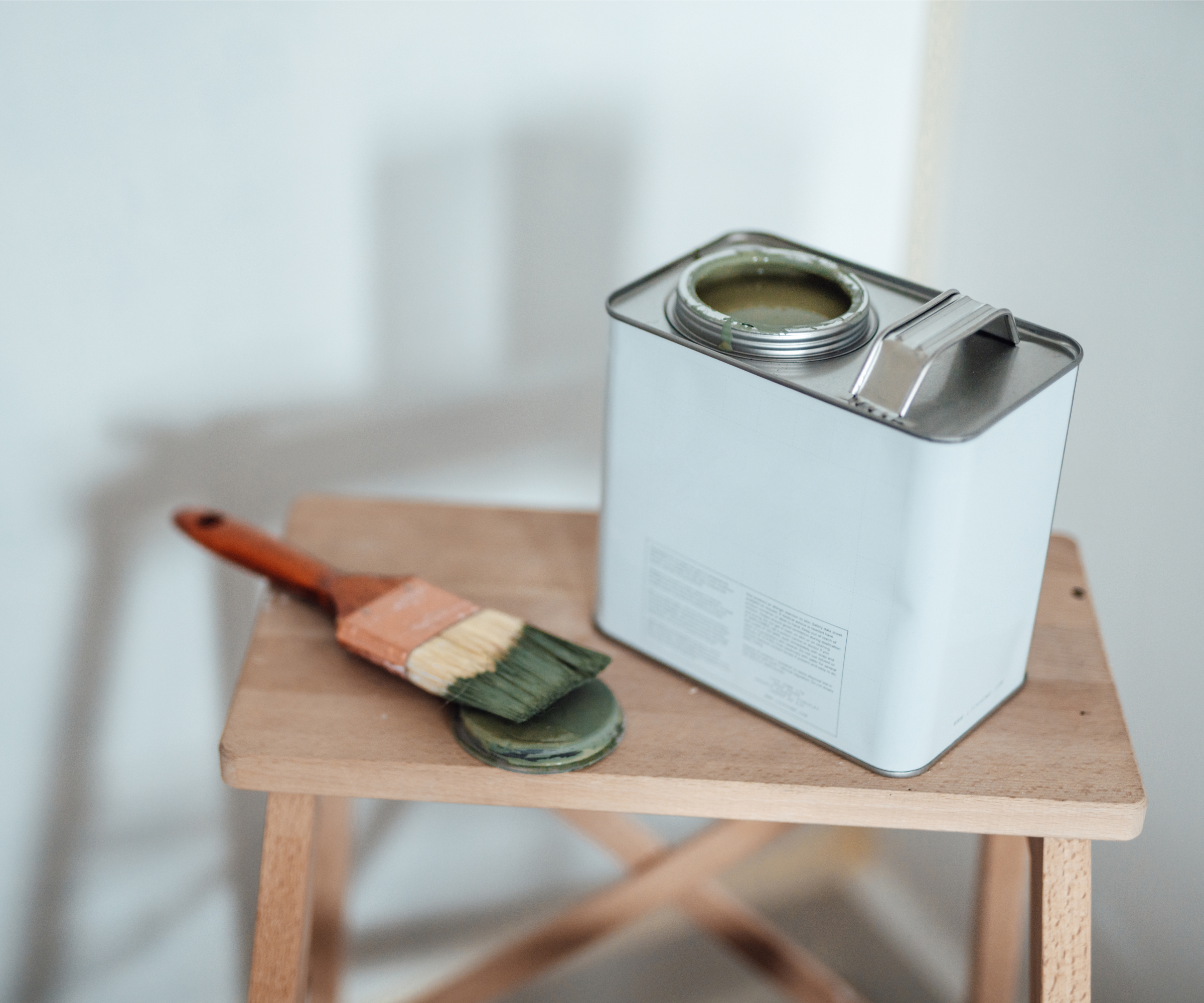 A paintbrush and can resting on a platform