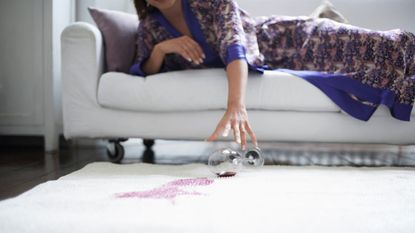 How to remove wine stains, Woman Reaching for Fallen Wine Glass 