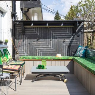Patio garden with wooden decking and green wall tiles