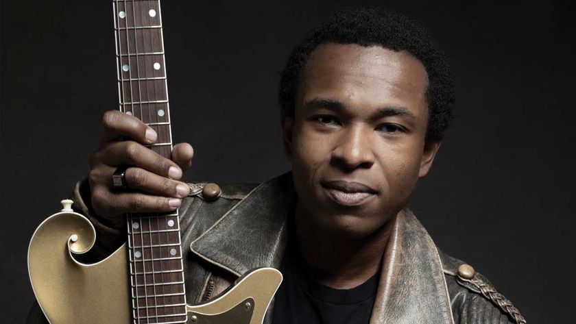 Solomon Hicks holding a guitar (studio portrait)