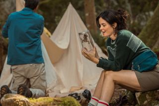 ashley sutton as frog researcher hannah holding a frog in a glass in season 3 episode 7 of yellowjackets