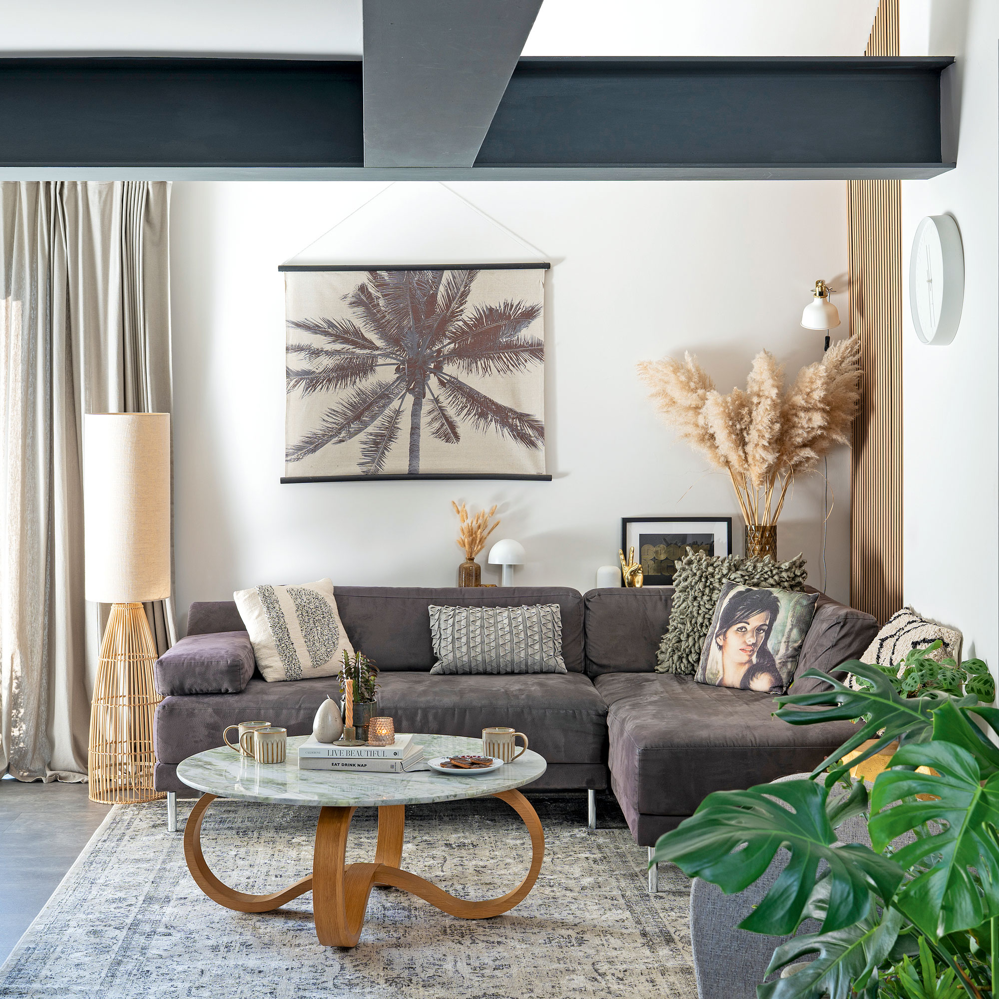 White living room with steel beams, grey sofa, marble coffee table and rattan lamp