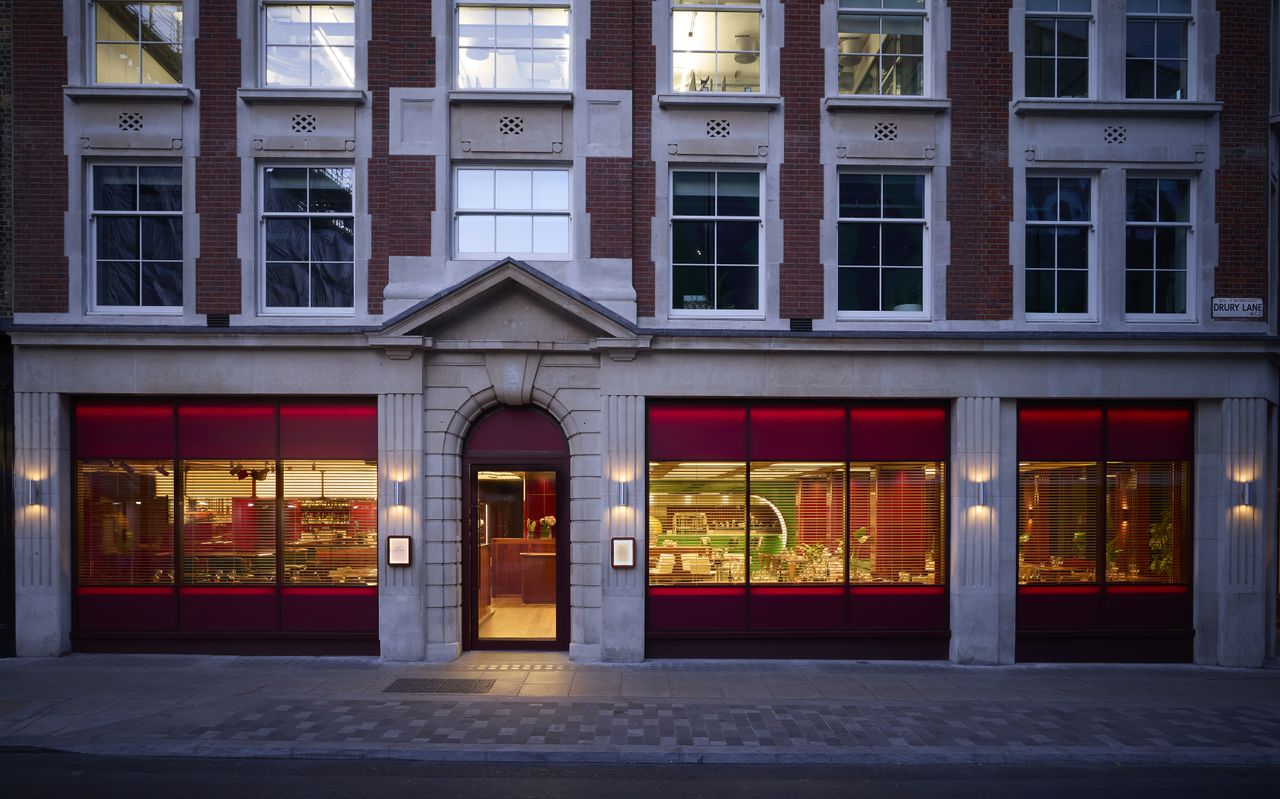 The exterior of a glamorous restaurant lets its warmth out onto an ornate, historical street.