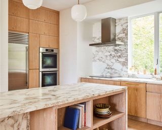 Wood kitchen cabinets with beige wall and marble counters