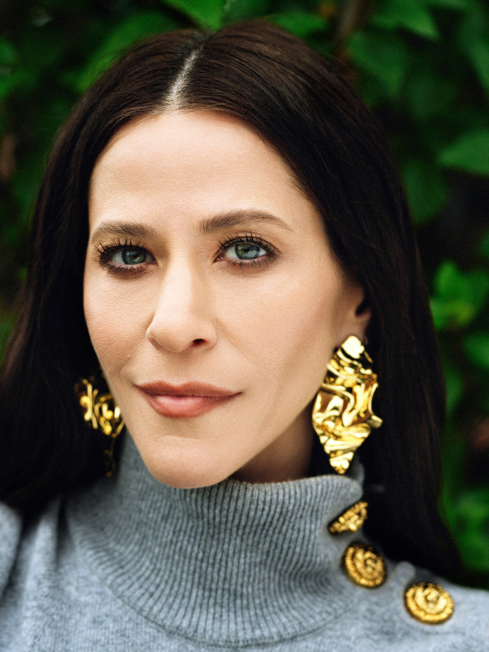 Jackie Tohn Portrait Session forBest Knockoff Luxury Clothing
. She is wearing a gray Balmain turtleneck sweater with gold button detailing on the left shoulder with matching skirt and trousers and white wedge heels and chunky Alexis Bittar jewelry.