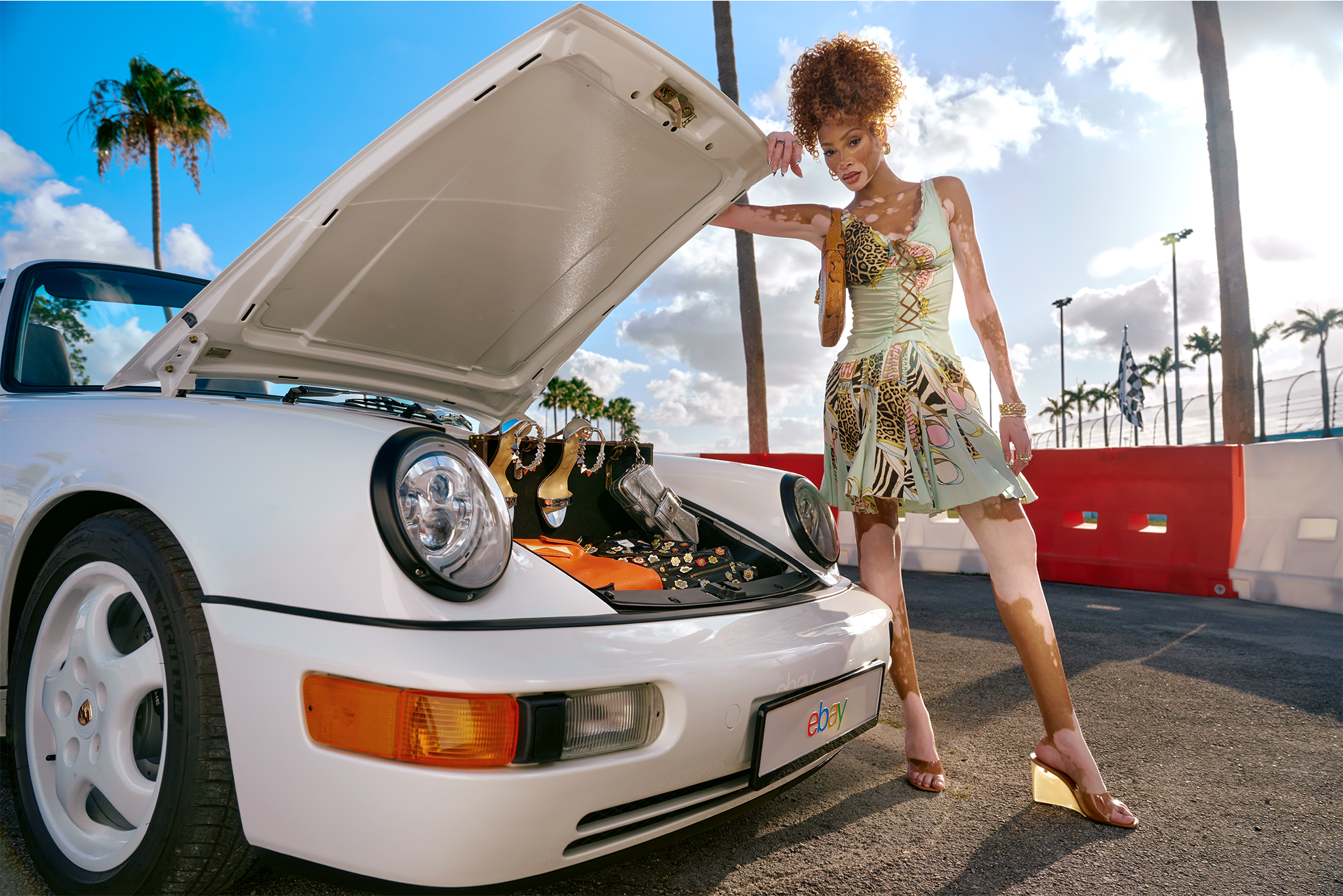 Winnie Harlow with a Porsche 911 wearing a vintage Roberto Cavalli dress with Amina Muaddi wedges.