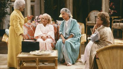 Golden girls cast in pyjamas sat in living room