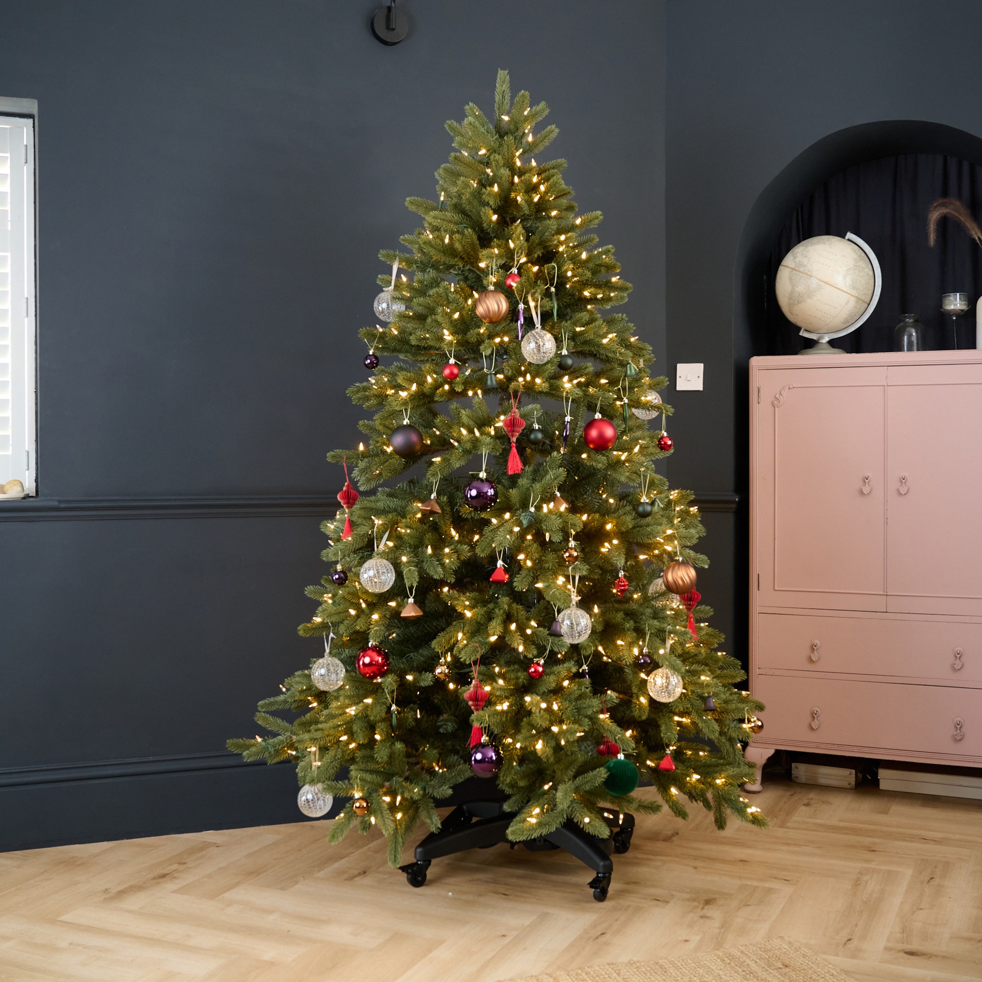 Balsam Hill's Vermont White Spruce Flip Tree in a black-painted living room decorated with Christmas baubles