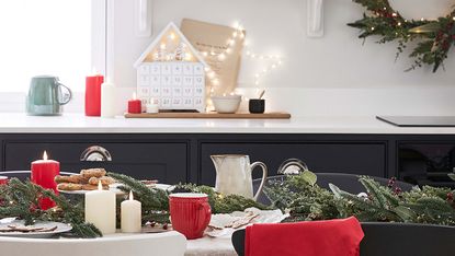 christmas decorations in a kitchen with advent calendar, greenery and red decor
