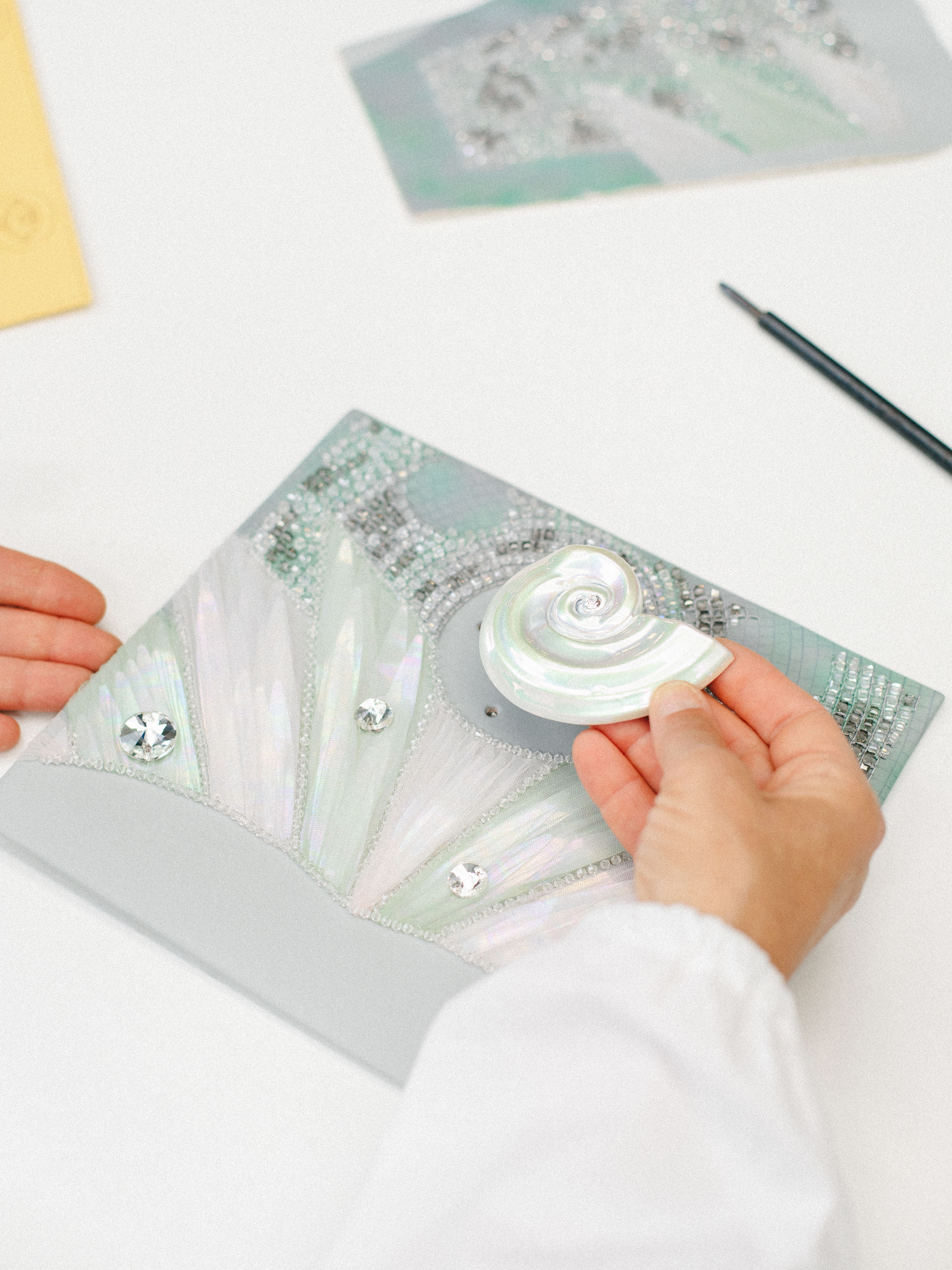 a craftsman creating a lady dior bag with shells