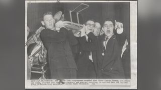 After Puerto Rican nationalists opened fire in the House Chamber in 1954, chaos erupted on the House Floor. House Pages Bill Goodwin, left, and Paul Kanjorski and Bill Emerson, both future Representatives, immediately sprang into action. They assisted five wounded Members, carrying the injured on stretchers through the hectic scene to ambulances waiting outside.