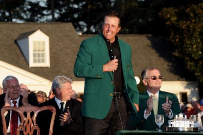 Mickelson wears the Green Jacket with a microphone in his hand