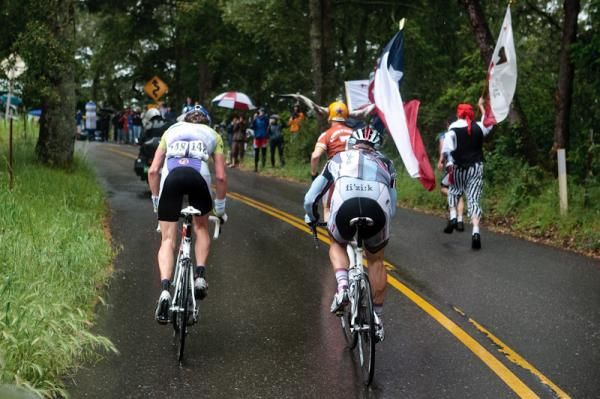 Fans run alongside the the lead group on a climb.