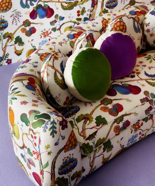 Sofa upholstered in Josef Frank Vegetable Tree print fabric with colourful cushions