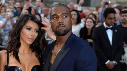 Kim Kardashian and Kanye West posing for crowd