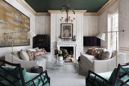 white and green living room with pleated floor lamps and botanical chandelier pendant by Studio Duggan