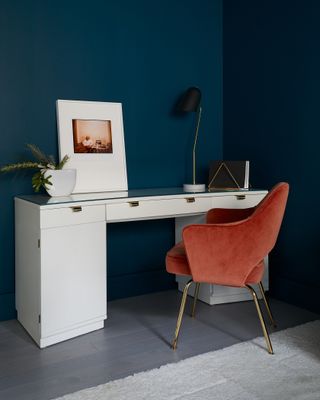 A study area with teal walls and a peach chair