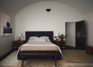 A bedroom with white walls, and a black headboard and door