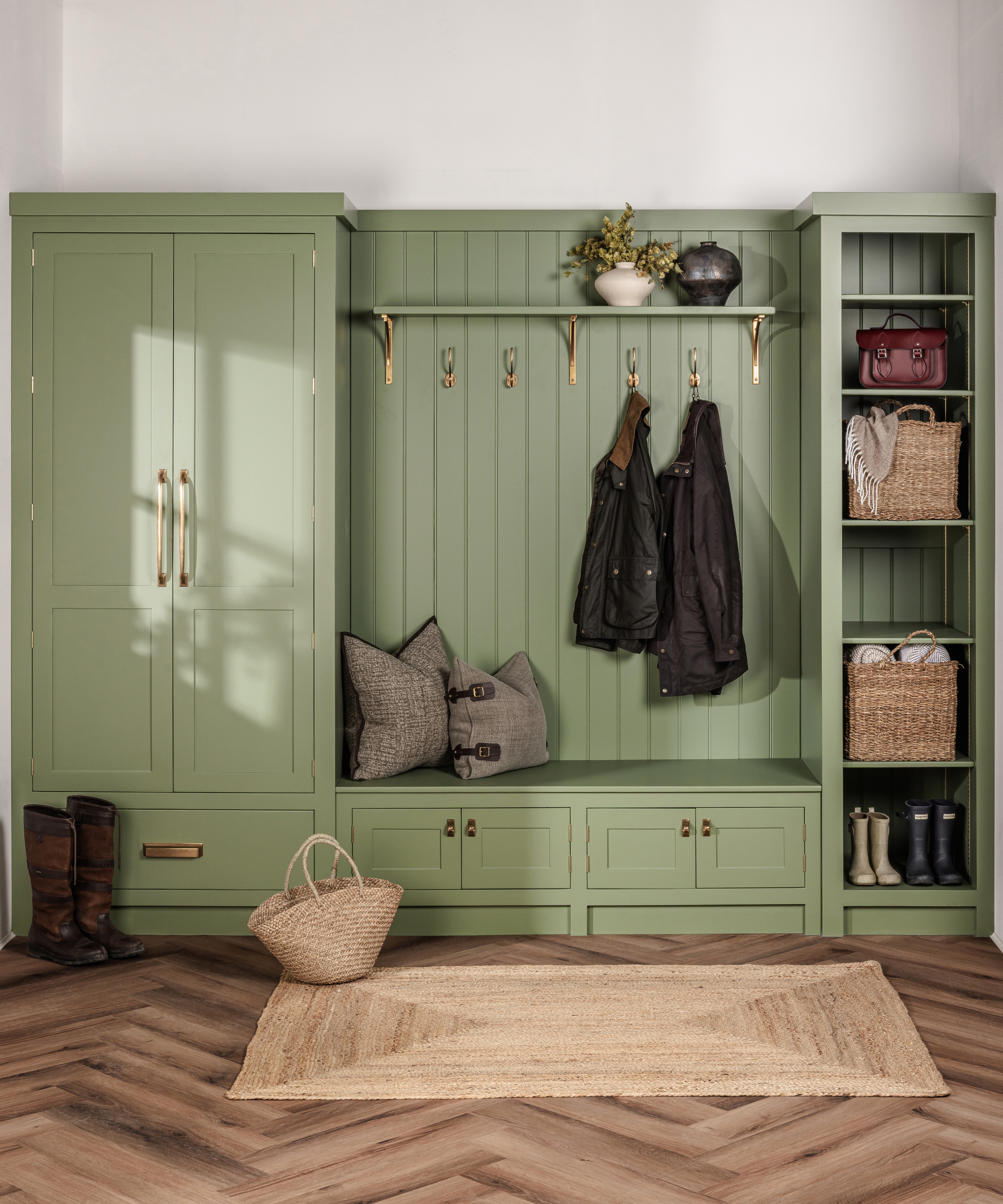 green built in boot room storage with matt brass handles and coat hooks