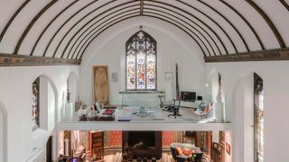 inside view of converted chapel with glass mezzanine and vaulted ceiling