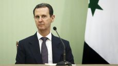 President Bashar al-Assad of Syria in front of a flag