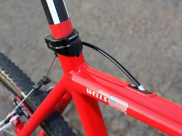 The tall seatpost collar presumably extra-tightly on the carbon post. The rear brake cable exits through the removable access port for easier routing.