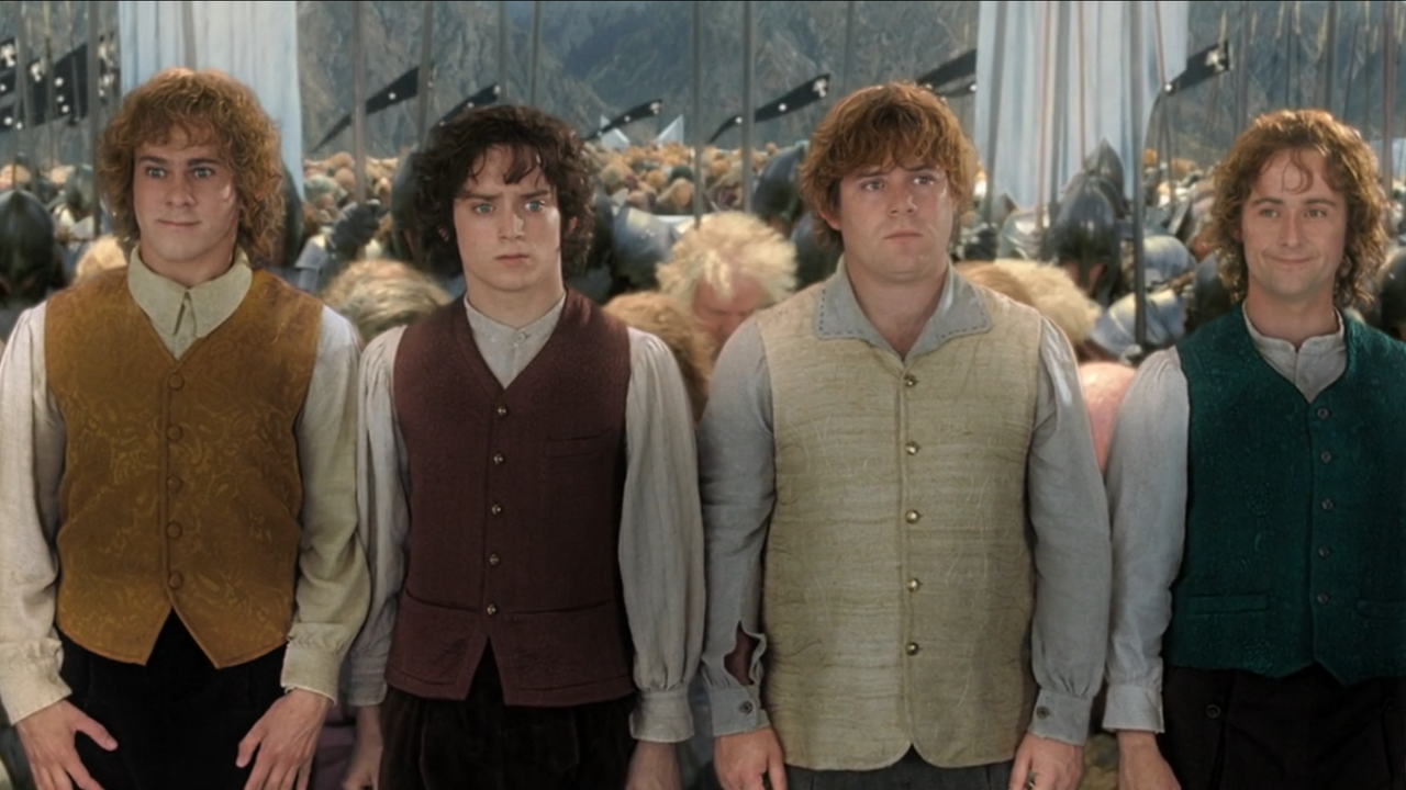 De izquierda a derecha: Merry, Frodo, Sam y Pippin al final de El regreso del rey cuando todos se inclinan ante ellos.