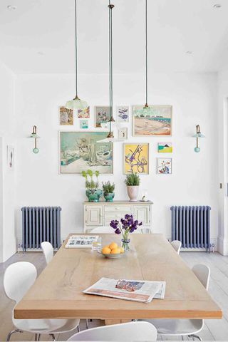 Dining room with pendant light and colorful vintage gallery wall