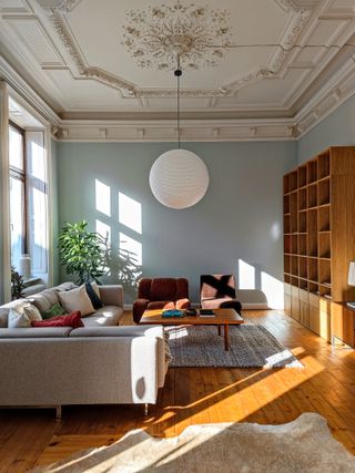 A living room with blue walls and beige ceiling