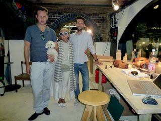 Left to Right - Tom Dixon holding his dog molly, Rosanna Orlandi and Simona Hasan, posing (standing) for a picture in a shop