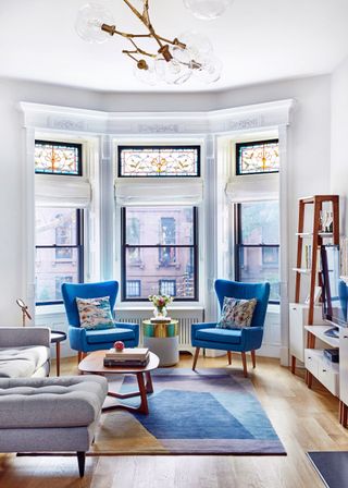 A living room with two blue chairs in the corner