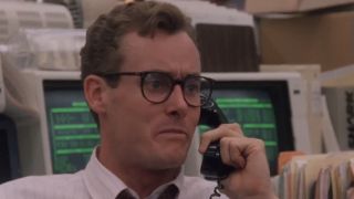 John C. McGinley wearing glasses and talking on the phone in Wall Street.