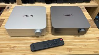 Two WiiM Amp products showing two different finishes and remote control