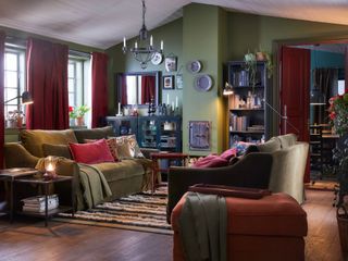 A traditional olive green living room with heavy red curtain drapes