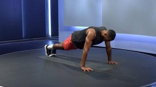 Peloton instructor Jermaine Johnson demonstrates the starting position of the push-up exercise