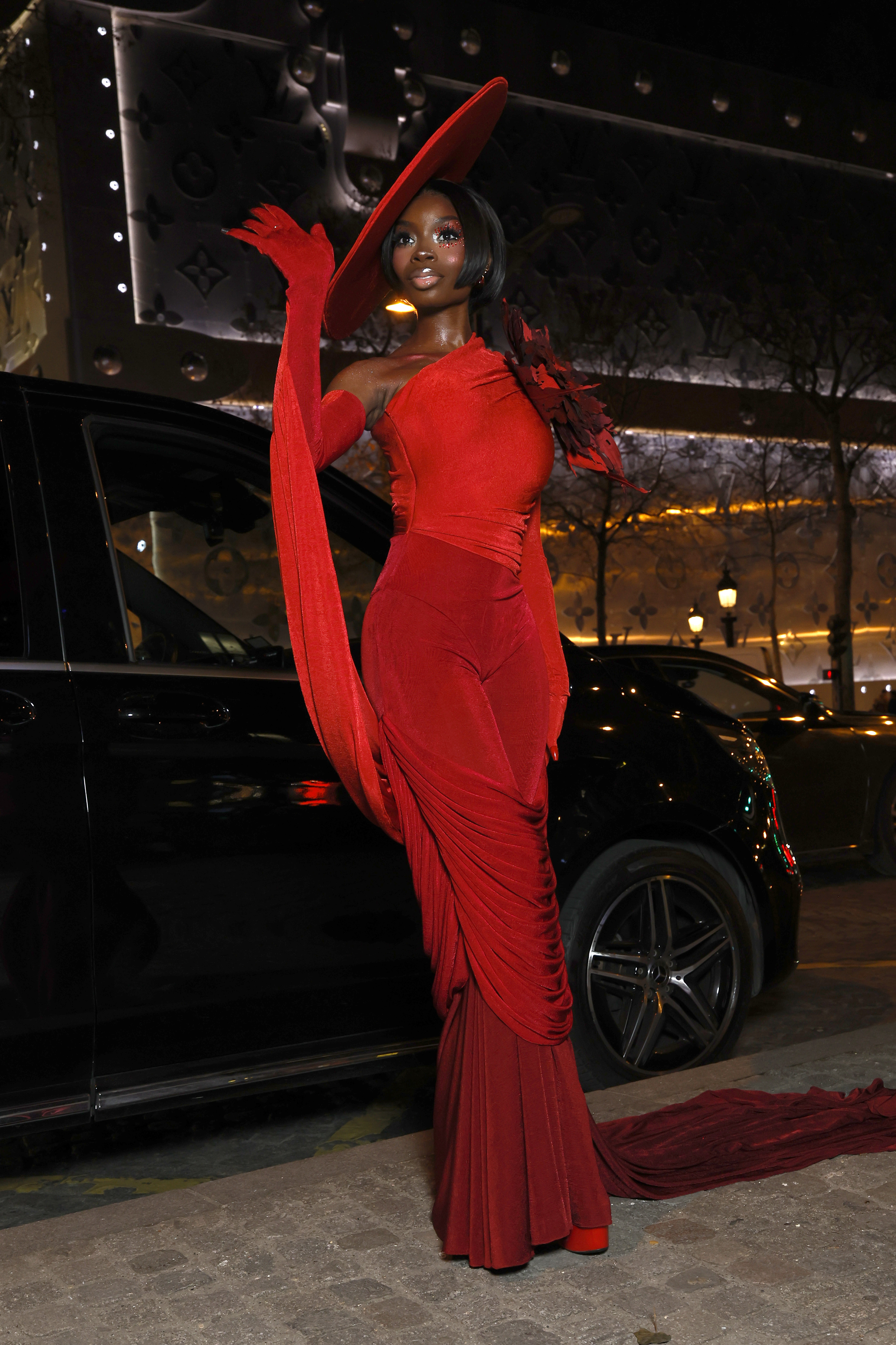 Olandria Carthen returned to Paris Couture Week wearing a red Robert Wun jumpsuit and matching hat