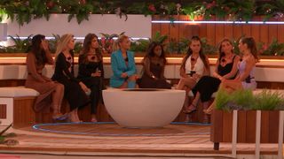 the women of the Love Island winter 2023 cast sat around the fire pit