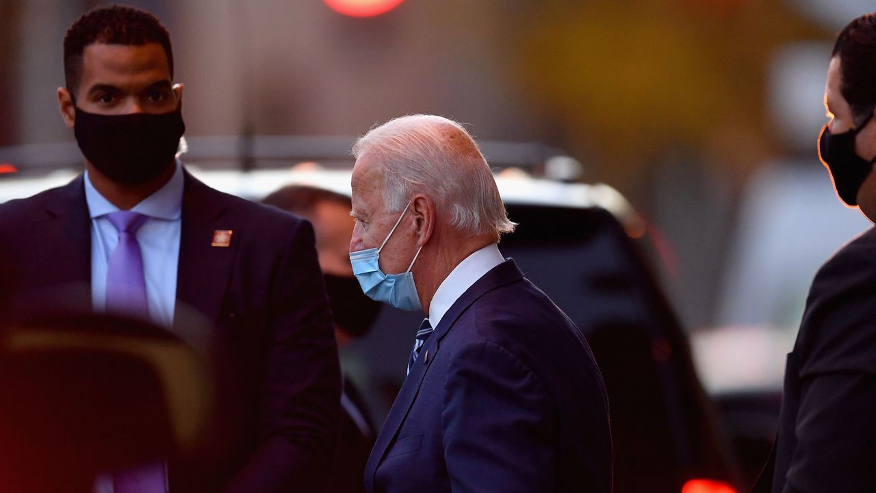 Joe Biden leaves The Queen hotel in Delaware flanked by security personnel.